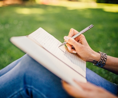 writing in a journal outdoors